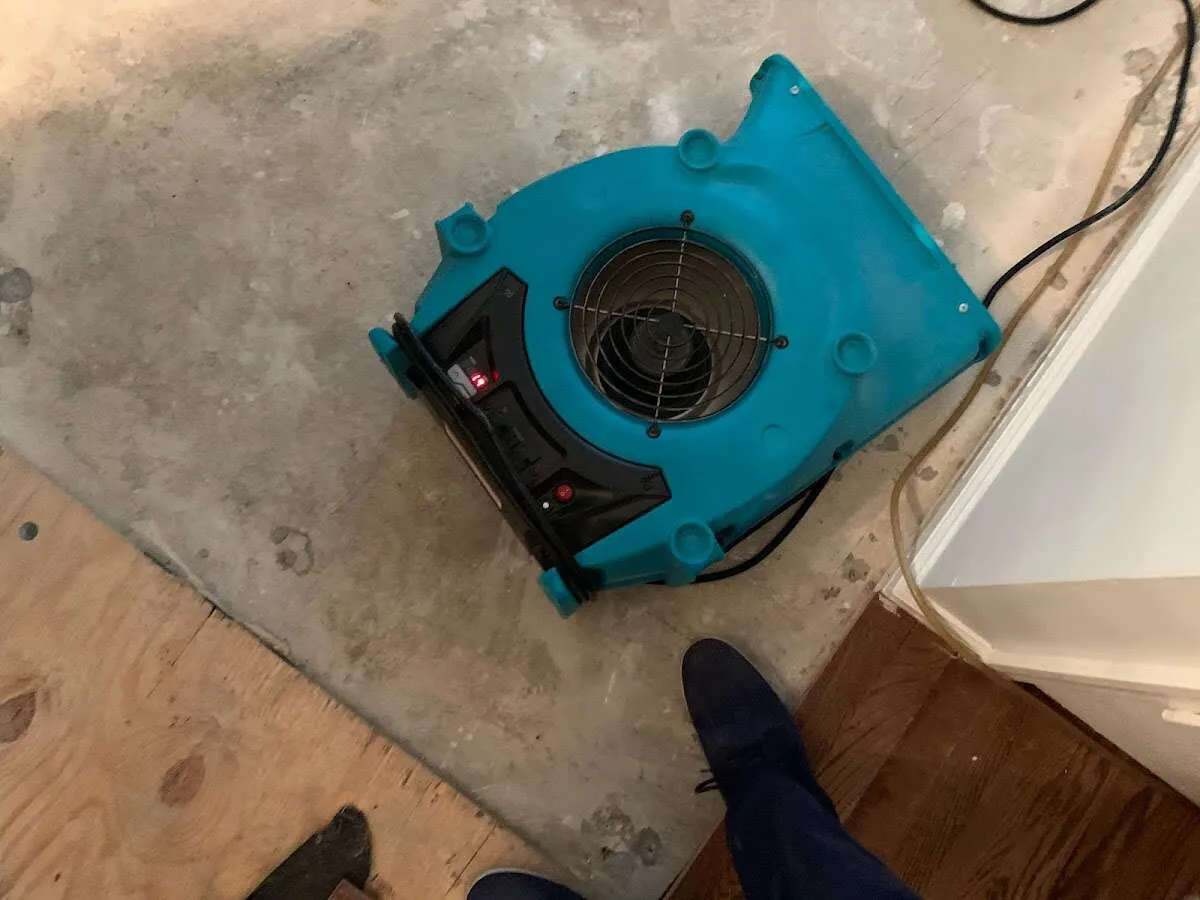 Air mover drying subfloor during Commercial Water Damage Restoration in Logan
